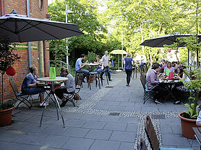 Latücht-Garten mit essenden Menschen an Tischen während einer Veranstaltung